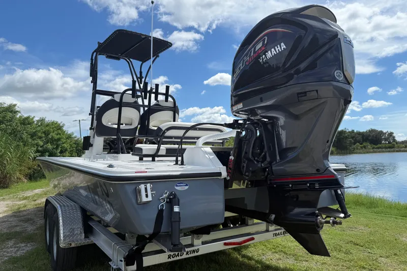 Slide: The Image of 2025 Tidewater 25 TPC Raptor boat with Yamaha engine on trailer by a lake. - 6