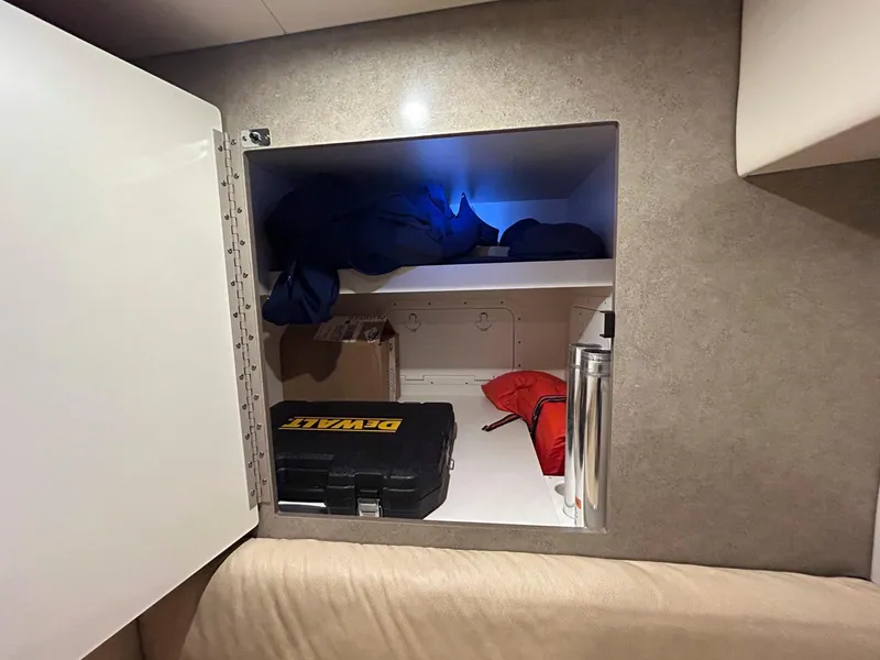 Slide: The Image of Open storage compartment in a 2007 Formula 40 PC boat, containing tools and equipment. - 27