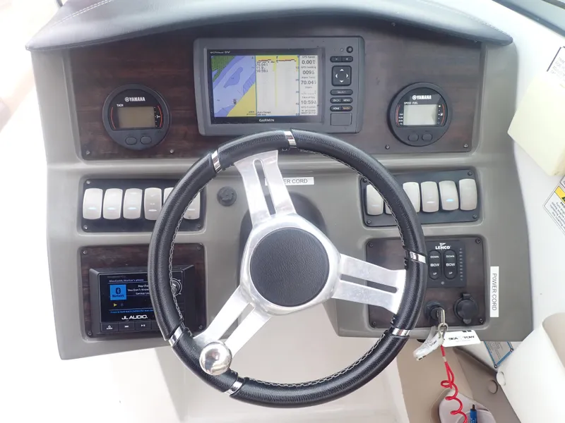 Slide: The Image of 2016 Hurricane SunDeck 2690 OB boat dashboard with steering wheel and navigation controls. - 13