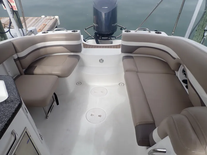 Slide: The Image of 2016 Hurricane SunDeck 2690 OB boat interior with beige seating and outboard motor. - 21