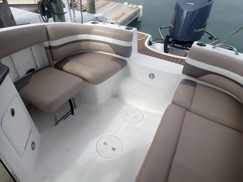 Slide: The Image of 2016 Hurricane SunDeck 2690 OB boat interior with cushioned seating and outboard motor. - 22