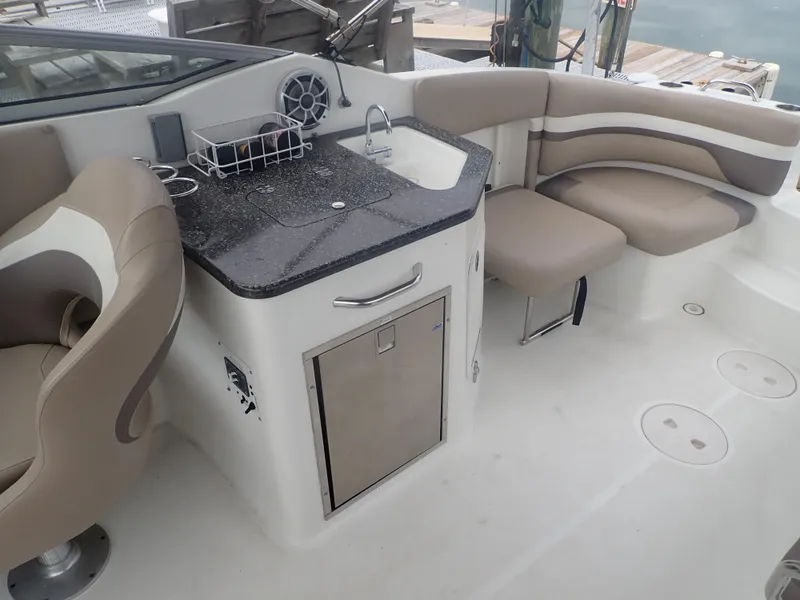 Slide: The Image of 2016 Hurricane SunDeck 2690 OB boat interior with seating and kitchenette area. - 24
