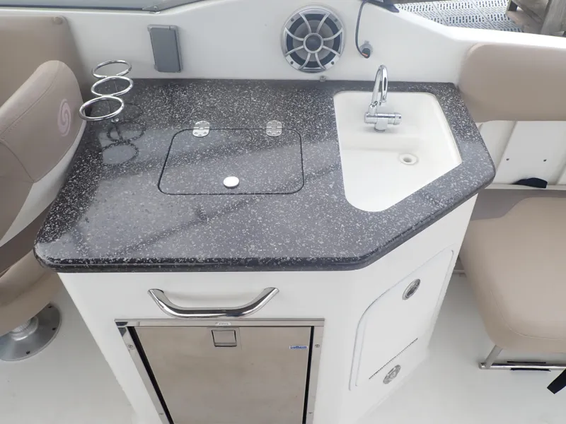 Slide: The Image of 2016 Hurricane SunDeck 2690 OB boat kitchenette with sink, countertop, and storage. - 25