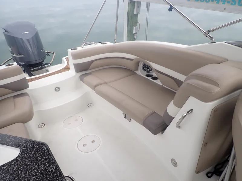 Slide: The Image of 2016 Hurricane SunDeck 2690 OB boat interior with beige seating and outboard motor. - 28