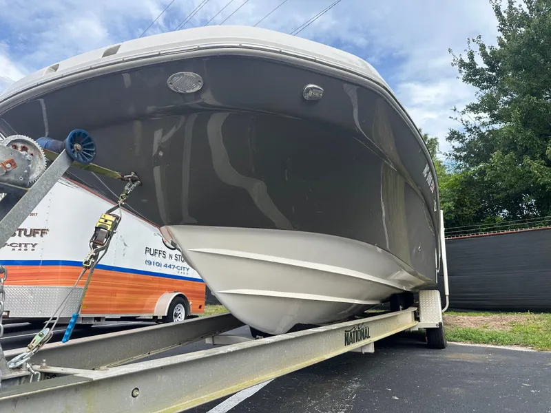 Slide: The Image of 2016 Hurricane SunDeck 2690 OB boat on trailer, parked outdoors. - 3