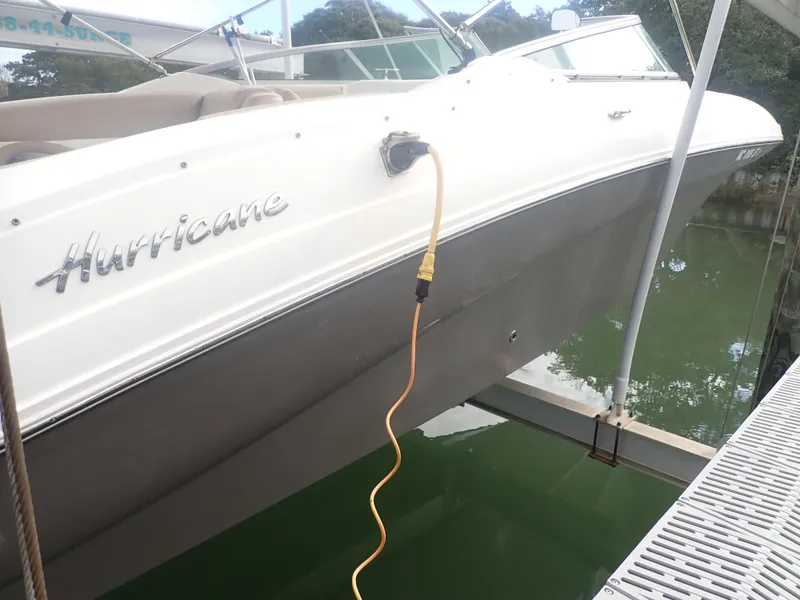Slide: The Image of 2016 Hurricane SunDeck 2690 OB boat docked with power cable connected. - 33