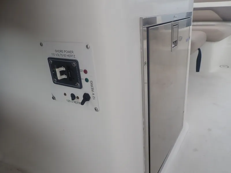 Slide: The Image of 2016 Hurricane SunDeck 2690 OB boat interior with power panel and stainless steel compartment. - 36