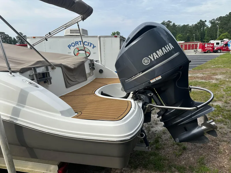 Slide: The Image of 2016 Hurricane SunDeck 2690 OB boat with Yamaha outboard motor, parked outdoors. - 48
