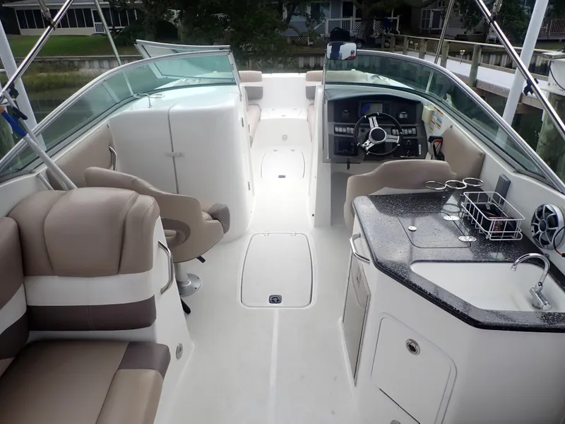 Slide: The Image of 2016 Hurricane SunDeck 2690 OB boat interior with seating, steering console, and kitchenette. - 7