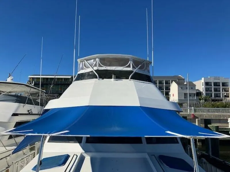 Slide: The Image of 1996 Hatteras 70 Sport Deck Motor Yacht with blue canopy, docked in marina. - 11