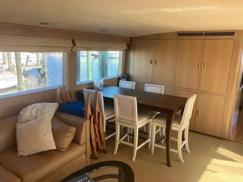 Slide: The Image of Interior of 1996 Hatteras 70 Sport Deck Motor Yacht with dining area and large windows. - 13