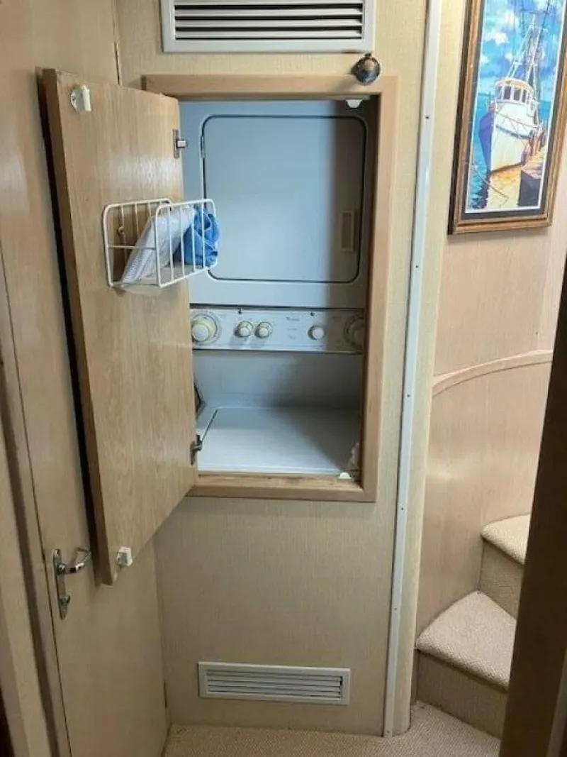 Slide: The Image of Laundry area inside 1996 Hatteras 70 Sport Deck Motor Yacht with stacked washer and dryer. - 32