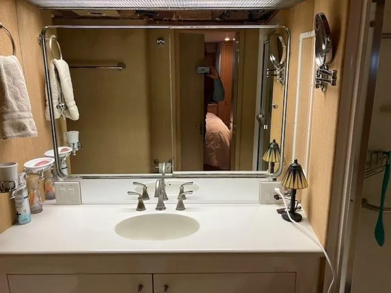 Slide: The Image of Bathroom vanity in 1996 Hatteras 70 Sport Deck Motor Yacht, featuring mirror and sink. - 35