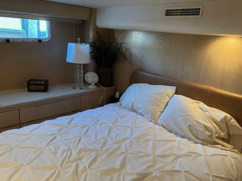 Slide: The Image of Bedroom interior of 1996 Hatteras 70 Sport Deck Motor Yacht, featuring cozy bed and elegant decor. - 36