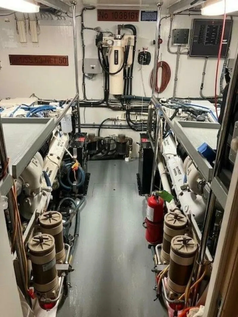 Slide: The Image of Engine room of 1996 Hatteras 70 Sport Deck Motor Yacht, featuring dual engines and equipment. - 39