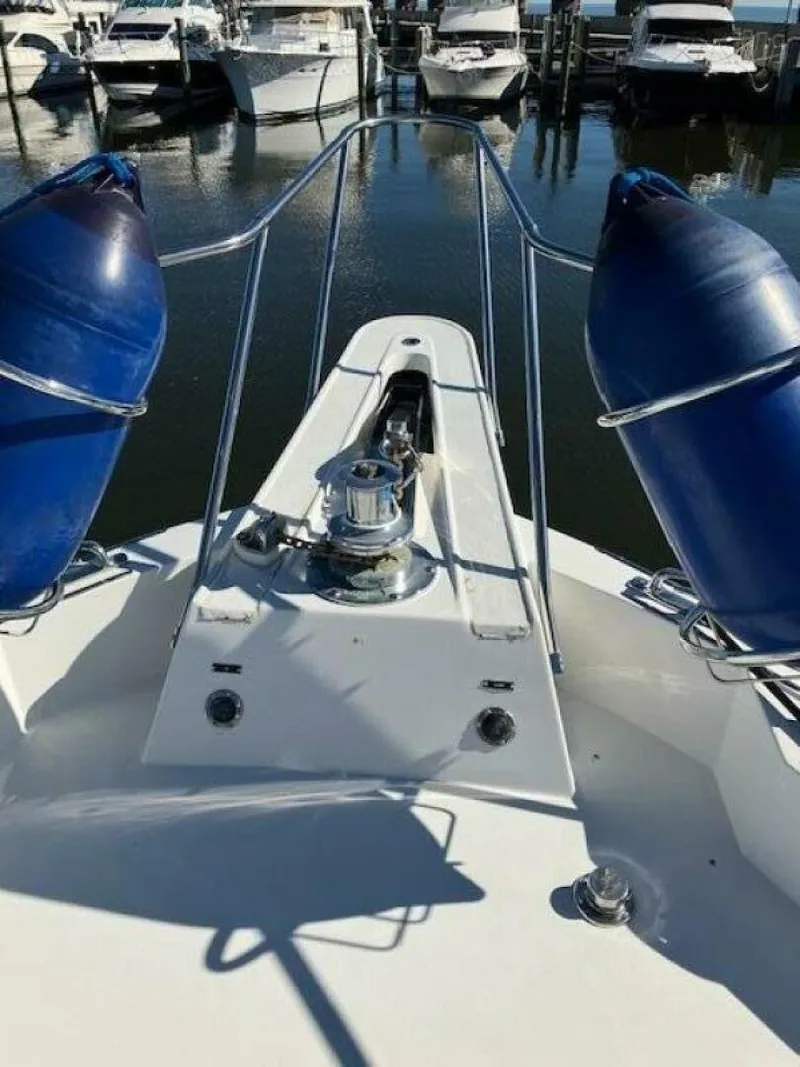 Slide: The Image of Bow of 1996 Hatteras 70 Sport Deck Motor Yacht with blue fenders in marina. - 9