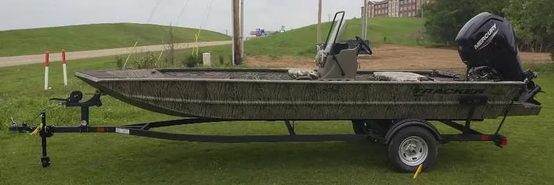 Slide: The Image of 2025 Tracker Grizzly 1860 CC boat on trailer, parked on grass. - 2