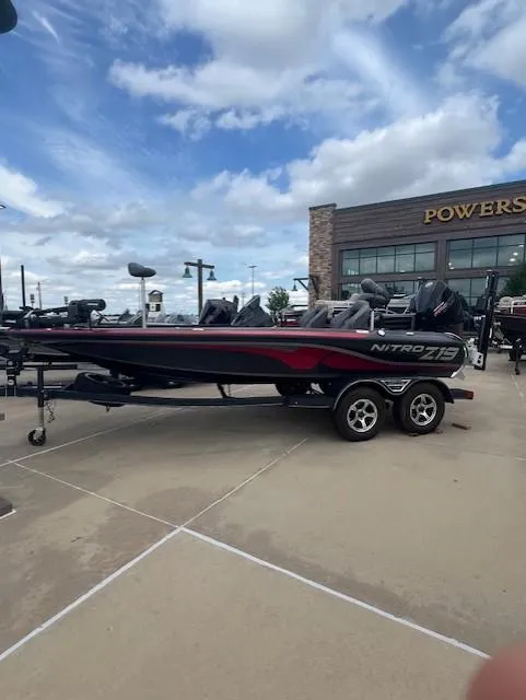 The Image of 2023 Nitro Z19 Pro boat on trailer, parked outside dealership under cloudy sky. - 0