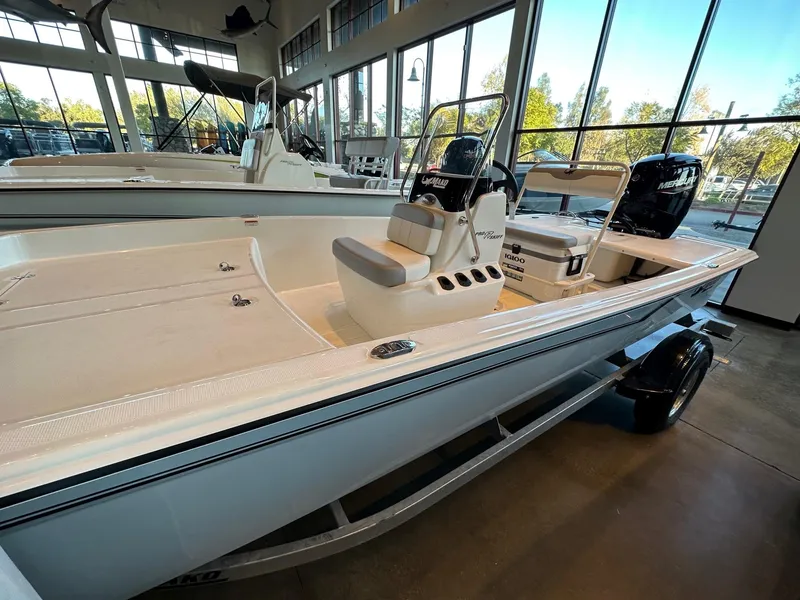Slide: The Image of 2025 Mako Pro Skiff 17 CC boat displayed in a showroom. - 2