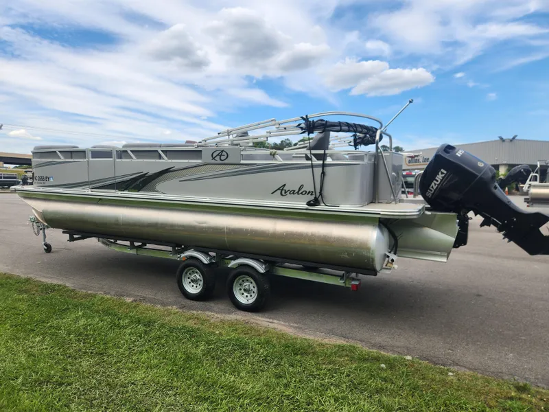 Slide: The Image of 2022 Avalon GS RF 2385 pontoon boat on trailer, parked outdoors under a cloudy sky. - 4