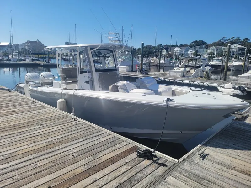 Slide: The Image of 2025 Sea Hunt Gamefish 28 Forward Seating boat docked at a marina under clear blue skies. - 0