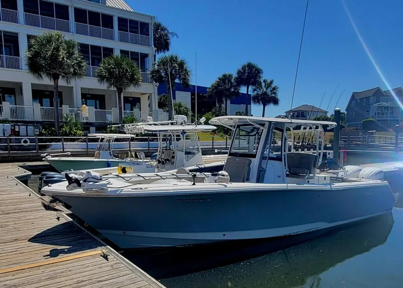 Slide: The Image of 2025 Sea Hunt Gamefish 28 Forward Seating boat docked at marina under clear blue sky. - 1