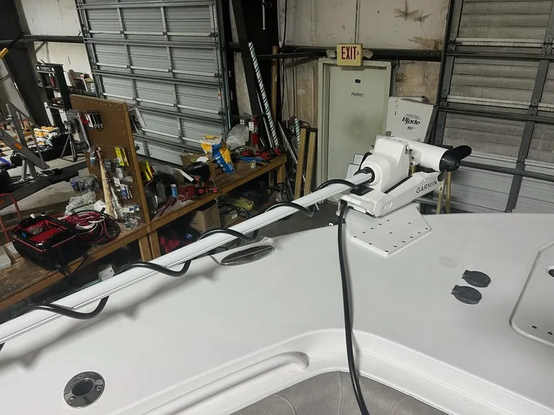 Slide: The Image of 2025 Sea Hunt Gamefish 28 with forward seating, featuring a mounted trolling motor in a workshop. - 11