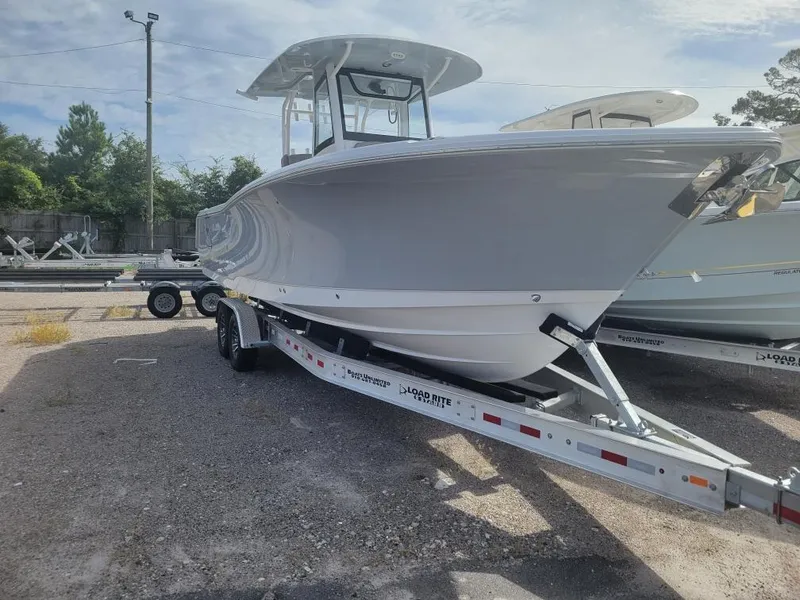Slide: The Image of 2025 Sea Hunt Gamefish 28 Forward Seating boat on trailer, parked outdoors. - 2