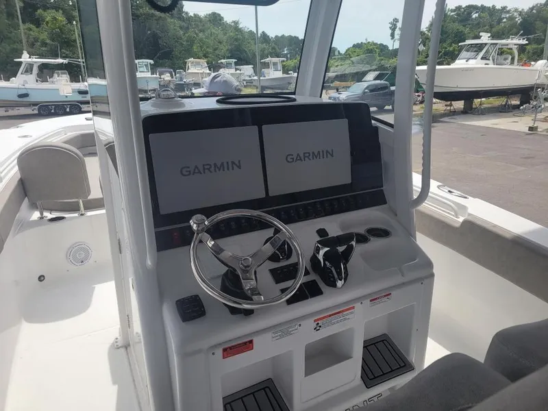 Slide: The Image of 2025 Sea Hunt Gamefish 28 boat dashboard with dual Garmin displays and steering wheel. - 7
