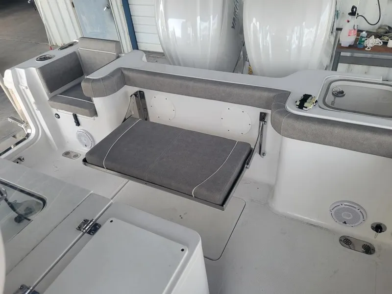 Slide: The Image of 2025 Sea Hunt Gamefish 28 Forward Seating interior with gray cushioned bench and storage compartments. - 9