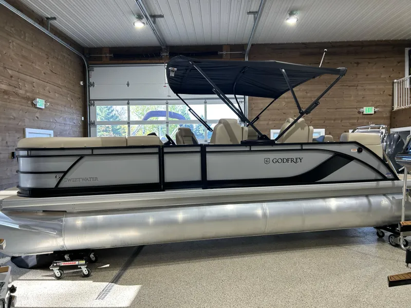 Slide: The Image of 2025 Godfrey Sweetwater 2286 QS pontoon boat in a showroom setting. - 1