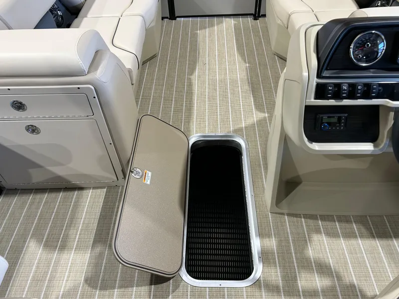 Slide: The Image of 2025 Godfrey Sweetwater 2286 QS boat interior with open storage compartment and beige seating. - 7