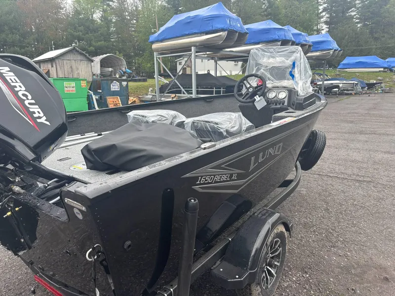Slide: The Image of 2025 Lund 1650 Rebel XL SS boat with Mercury engine, parked outdoors. - 3
