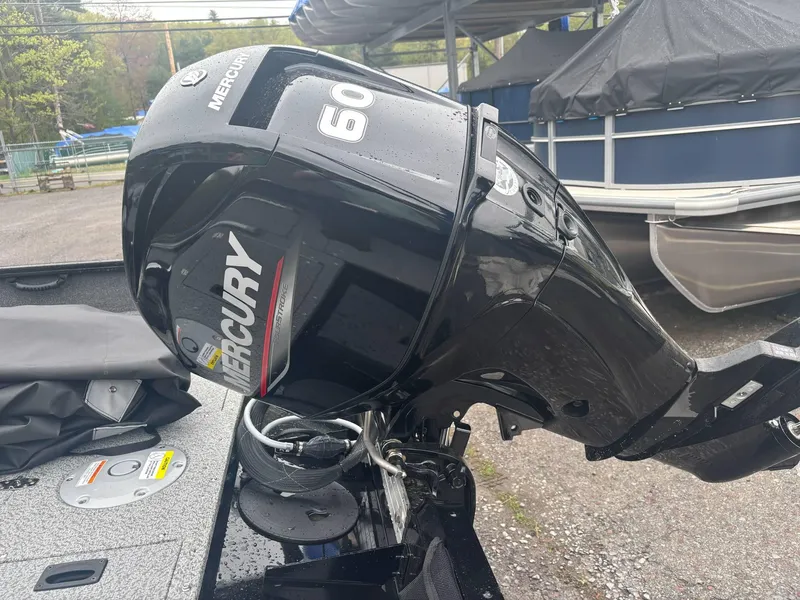 Slide: The Image of 2025 Lund 1650 Rebel XL SS with Mercury 60 outboard motor, parked outdoors. - 4