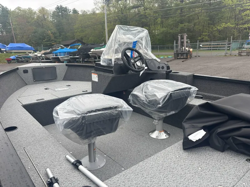 Slide: The Image of 2025 Lund 1650 Rebel XL SS boat interior with covered seats and steering wheel. - 5