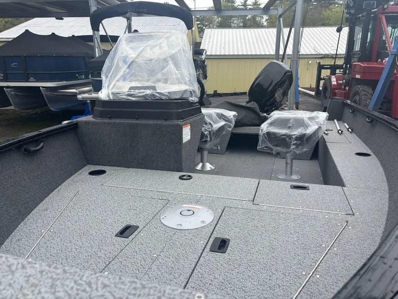 Slide: The Image of 2025 Lund 1650 Rebel XL SS fishing boat interior with covered seats and storage compartments. - 6