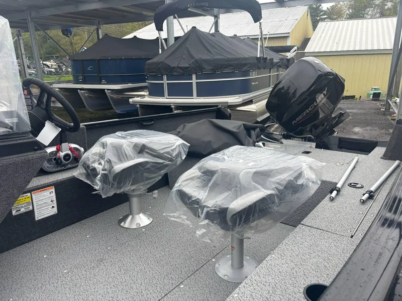 Slide: The Image of 2025 Lund 1650 Rebel XL SS boat interior with covered seats and motor. - 7