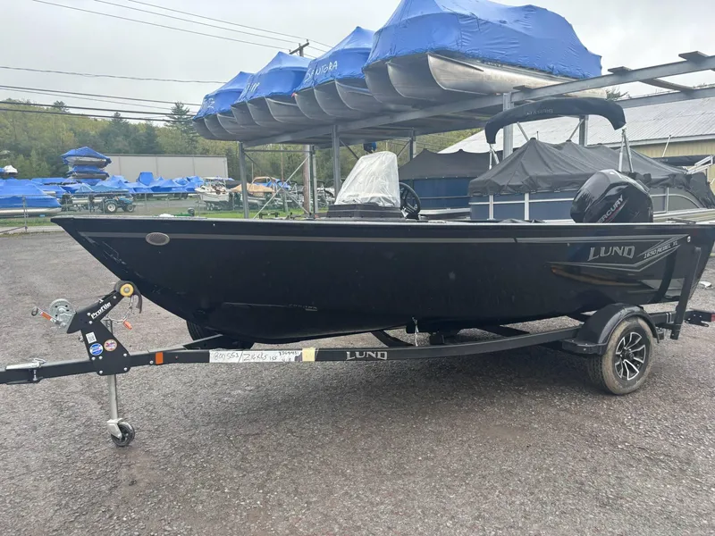 Slide: The Image of 2025 Lund 1650 Rebel XL SS boat on trailer, parked outdoors. - 9