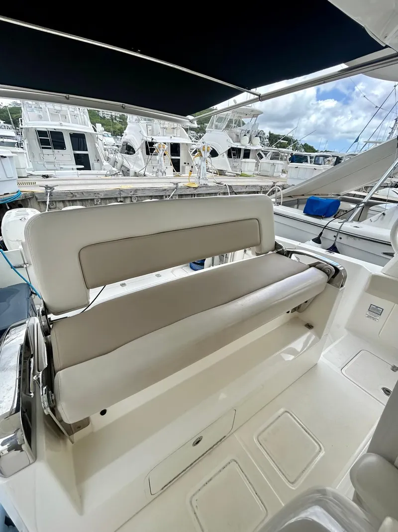 Slide: The Image of 2019 Boston Whaler 420 Outrage boat interior with seating, docked at marina. - 12