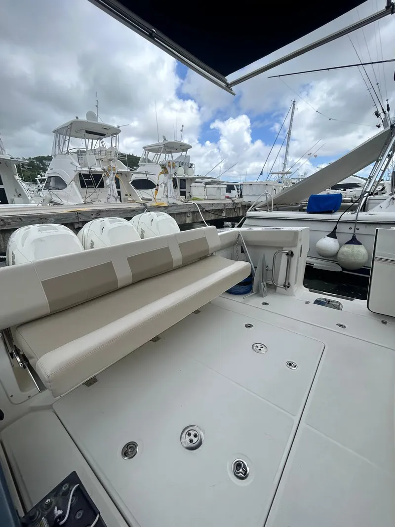 Slide: The Image of 2019 Boston Whaler 420 Outrage boat interior with seating, docked at marina. - 13