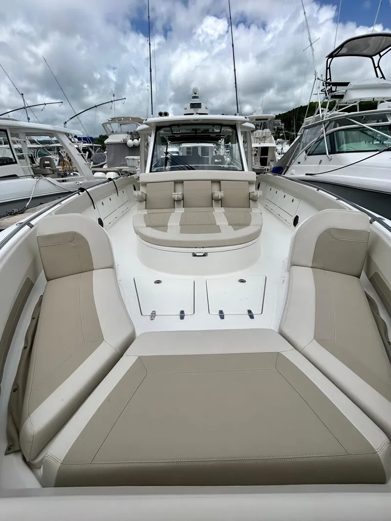 Slide: The Image of 2019 Boston Whaler 420 Outrage boat with spacious seating, docked at a marina. - 4