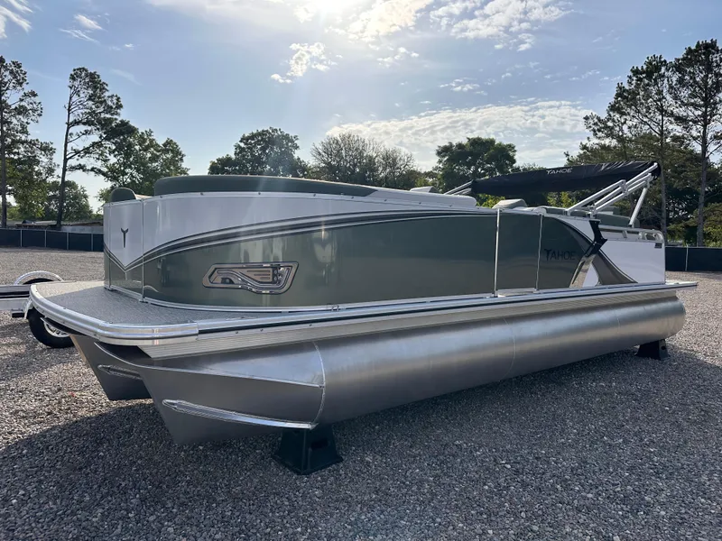 Slide: The Image of 2025 Tahoe Pontoon LTZ Cruise Rear Bench on gravel lot, under sunny sky. - 1
