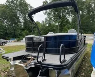 Slide: The Image of 2025 Bennington 22 SXSR pontoon boat with canopy, parked outdoors. - 3