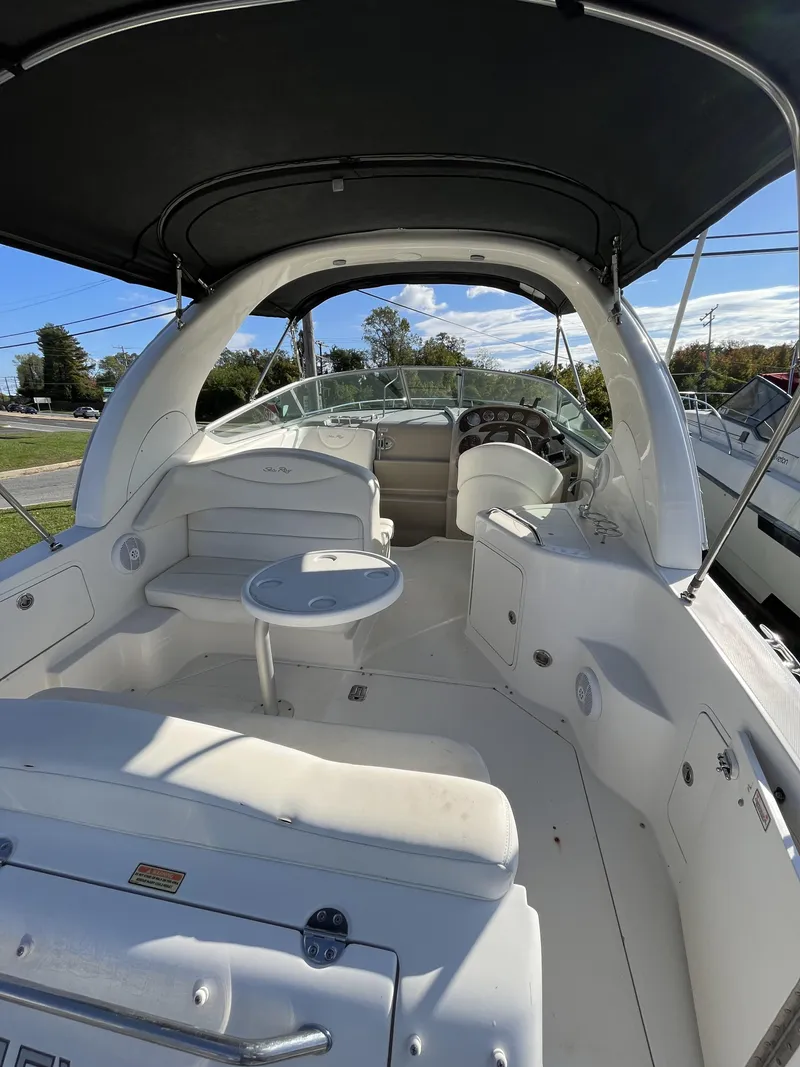 Slide: The Image of 2006 Sea Ray 280 Sundancer boat interior with seating and helm under canopy. - 2