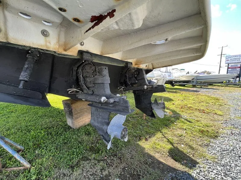 Slide: The Image of 2006 Sea Ray 280 Sundancer boat underside showing dual propellers on grass. - 6