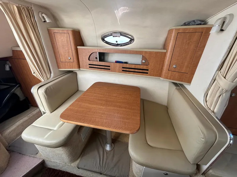 Slide: The Image of 2006 Sea Ray 280 Sundancer cabin with wooden table and beige seating. - 9