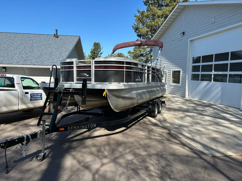 Slide: The Image of 2022 Bennington 22 SX SBST pontoon boat on trailer, parked outside a garage. - 3