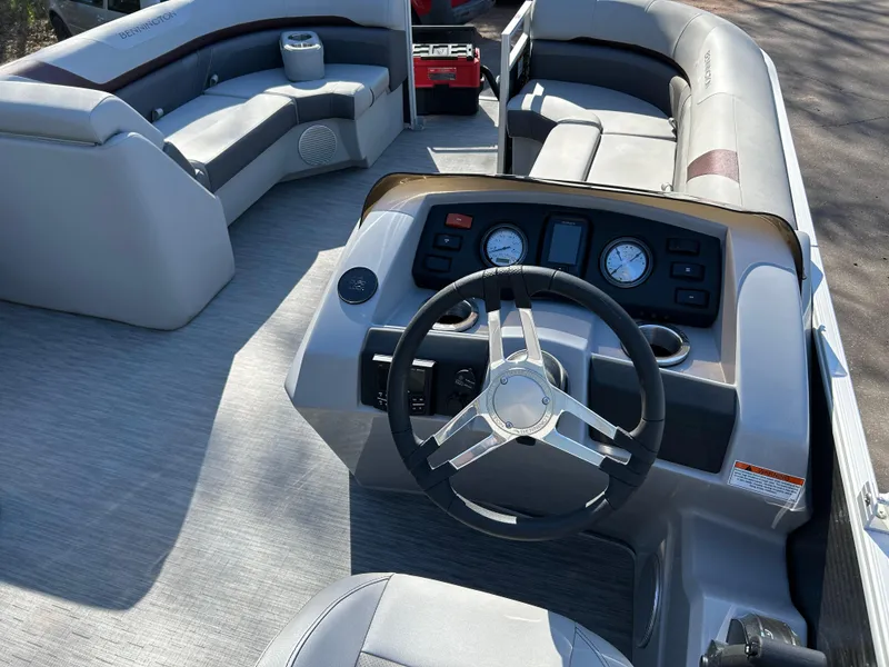 Slide: The Image of 2022 Bennington 22 SX SBST pontoon boat interior with steering wheel and seating area. - 5