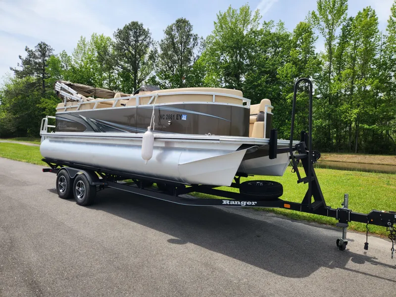 Slide: The Image of 2022 Avalon VLS 2080 QL pontoon boat on trailer, parked on road. - 1