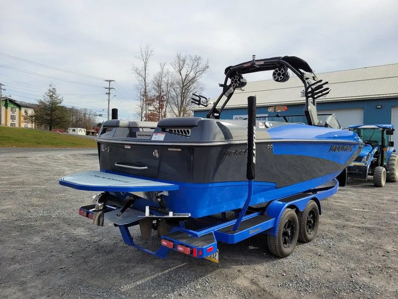 Slide: The Image of 2022 Moomba Makai boat on trailer, blue and black design, parked outdoors. - 5